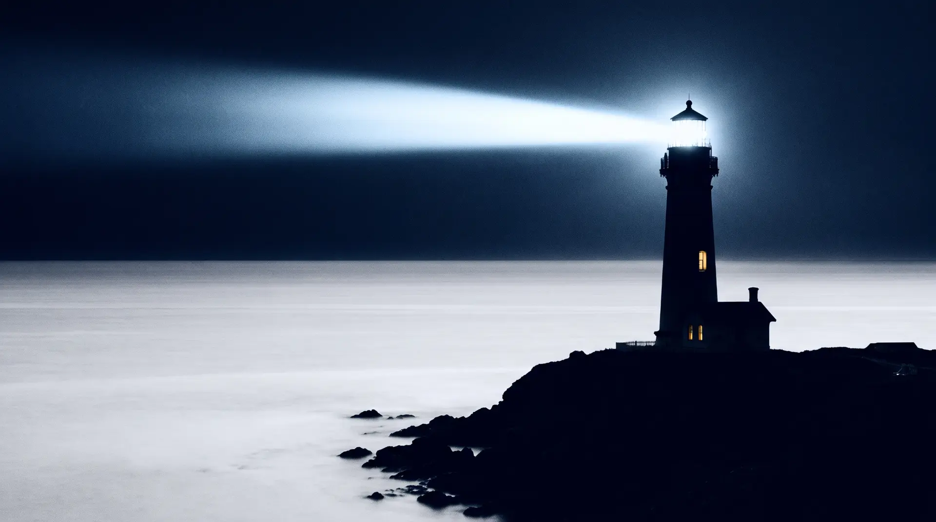 A lighthouse beam cutting across a dark sea at night